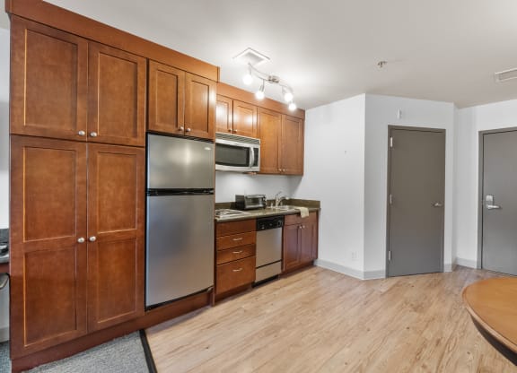 a kitchen with wooden cabinets and stainless steel appliances and a wooden table