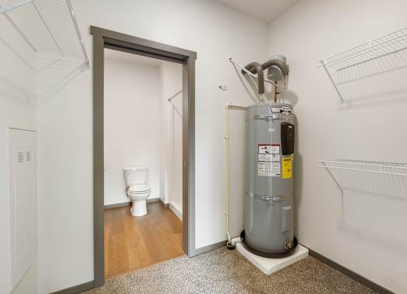 A room with a toilet, a heater and a door.