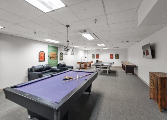 a game room with a pool table and two billiards tables