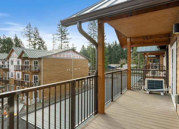 A wooden deck with a metal railing and a hot tub.
