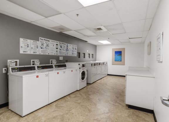 a laundry room with washers and dryers and a wall of papers and posters