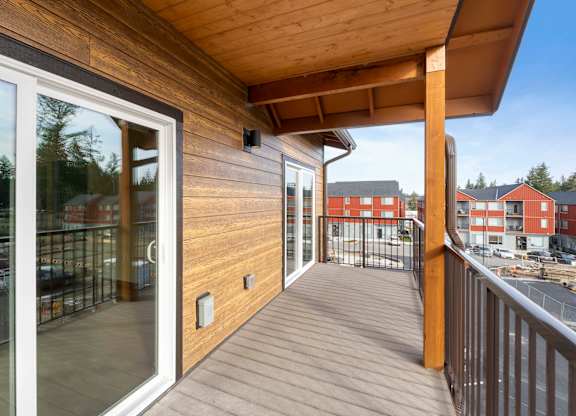 A balcony with a sliding glass door and a wooden railing.