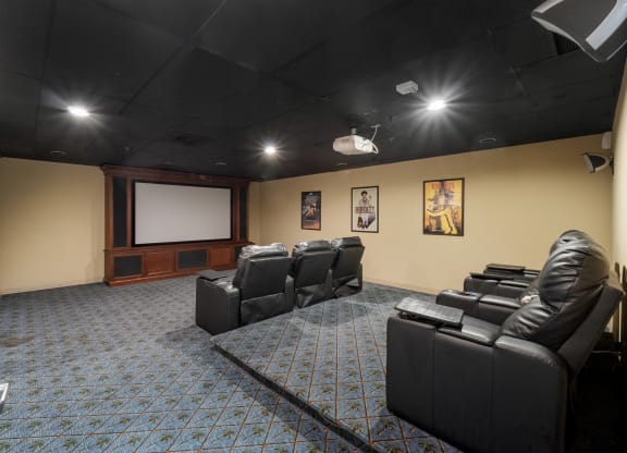 a large screening room with leather seats and a projector screen