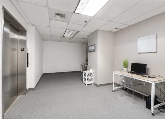 an empty room with a desk and a computer in it