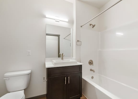 A white bathroom with a toilet, sink, and bathtub.