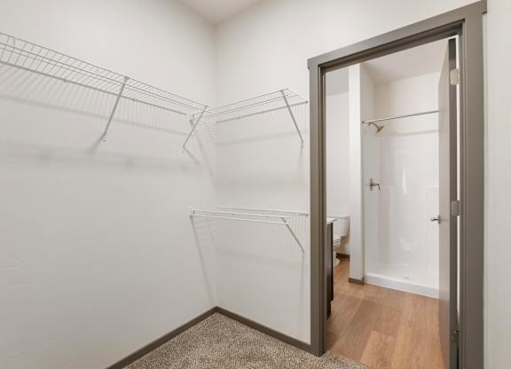 A white room with a grey door and a carpet on the floor.