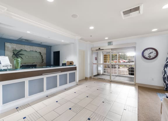 a reception area with a counter and a glass door