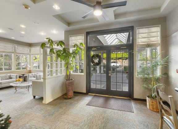 the lobby of a home with a glass door and a ceiling fan