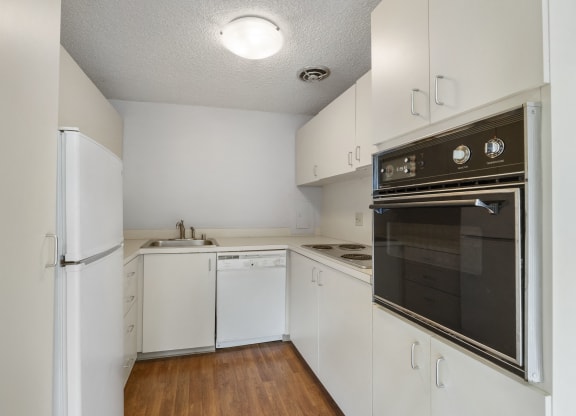 an empty kitchen with white cabinets and a black stove and refrigerator