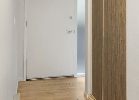 an empty room with a wooden floor and a white door