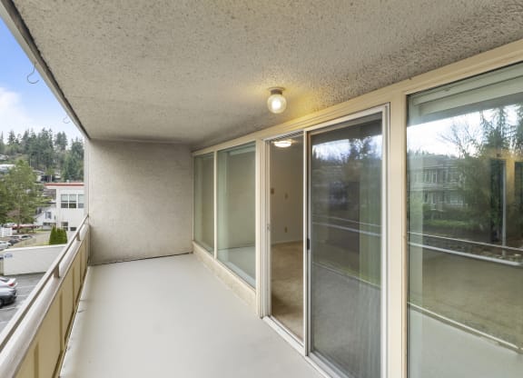 the living room of a condo with large windows and a balcony