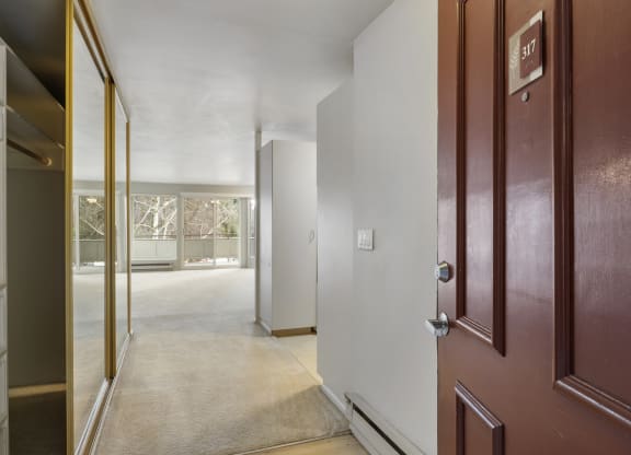a hallway with a door open to a room with a view of a living room