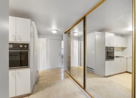 a renovated kitchen with white cabinets and stainless steel appliances