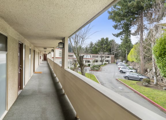 a long balcony with a view of a parking lot
