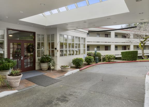 the entrance of a building with a driveway and a red door
