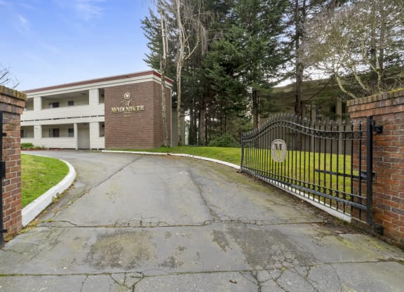 the entrance to a school with a wrought iron gate