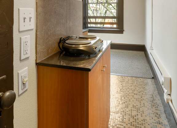 A kitchen with a wooden cabinet and a window.
