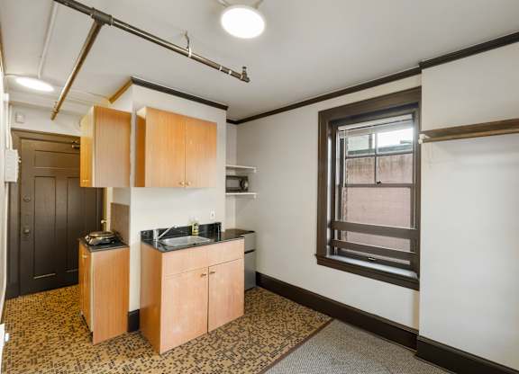 A kitchen area with wooden cabinets and a black countertop.