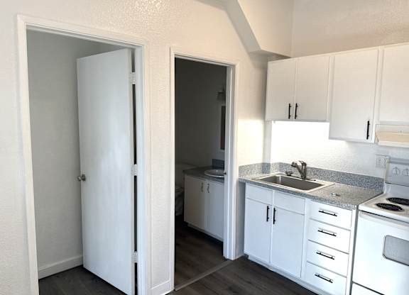 A kitchen with white appliances and cabinets.