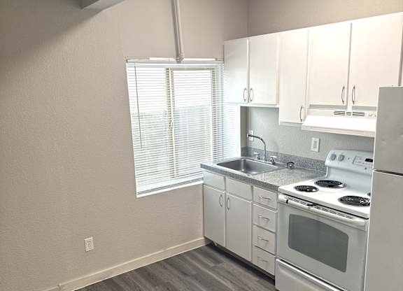 A kitchen with white appliances and wooden cabinets.