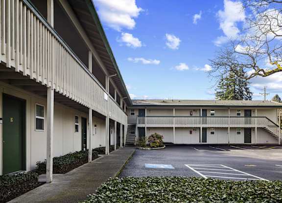 A long building with a green door and a white wall.