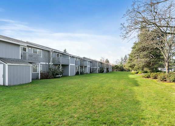 A long row of houses with green lawns in front.