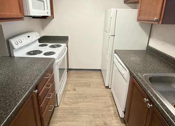 A kitchen with brown cabinets and a white stove top oven.