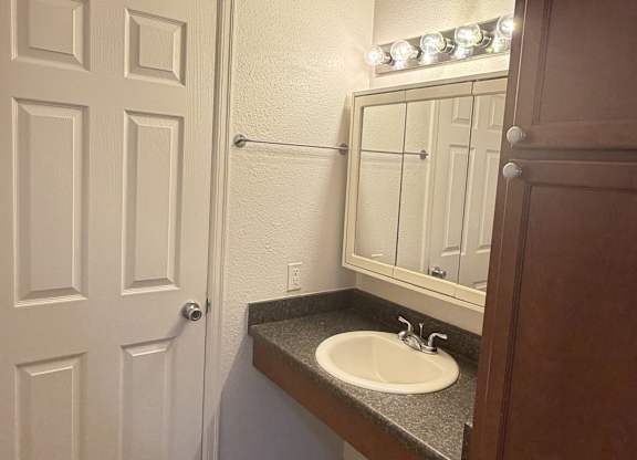 A bathroom with a sink and a mirror.