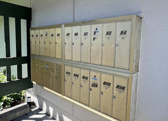A row of mailboxes are on the side of a building.