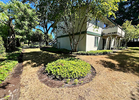 A white house with a tree in front of it.
