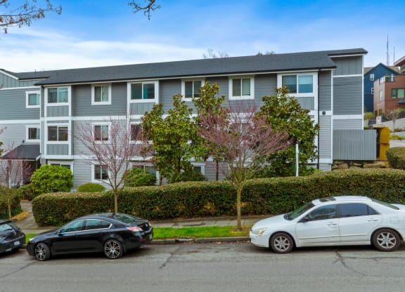 an apartment building with cars parked in front of it