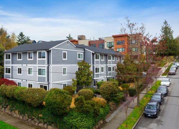an aerial view of a gray house with a street in front of it