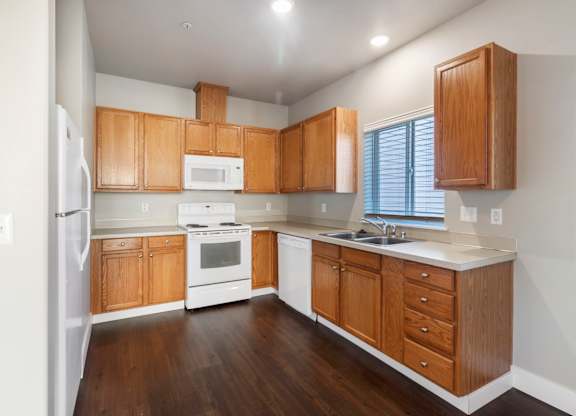 A kitchen with wooden cabinets and white appliances.