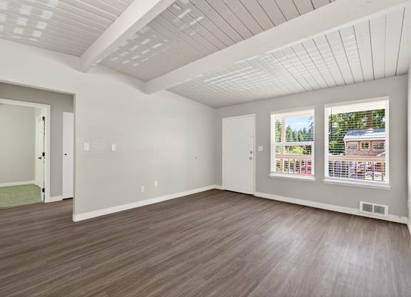 A room with a white ceiling and wooden flooring.