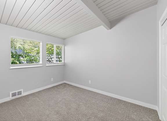 A room with a white ceiling and carpeted floor.