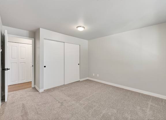 A room with a carpeted floor and a white door.