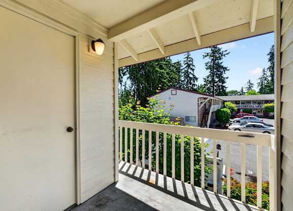 A white door is on the left of a balcony with a light on the ceiling.