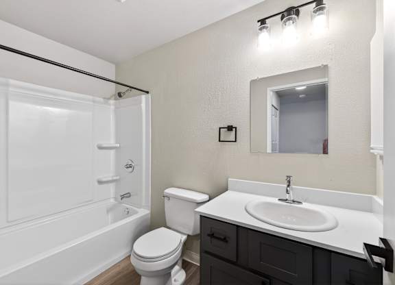 A white bathroom with a toilet, sink, and bathtub.