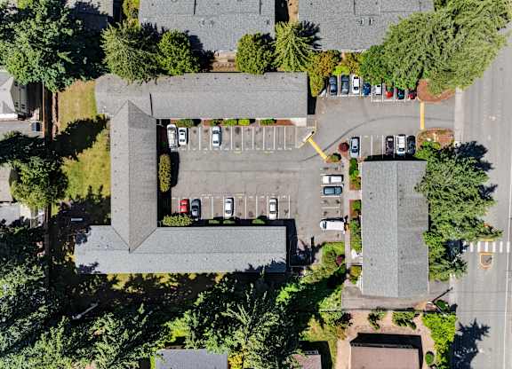 A parking lot with cars and a building in the background.
