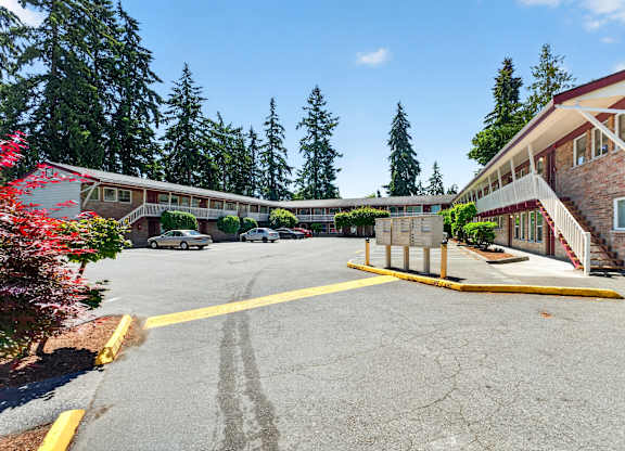 A parking lot with a yellow line and a building in the background.