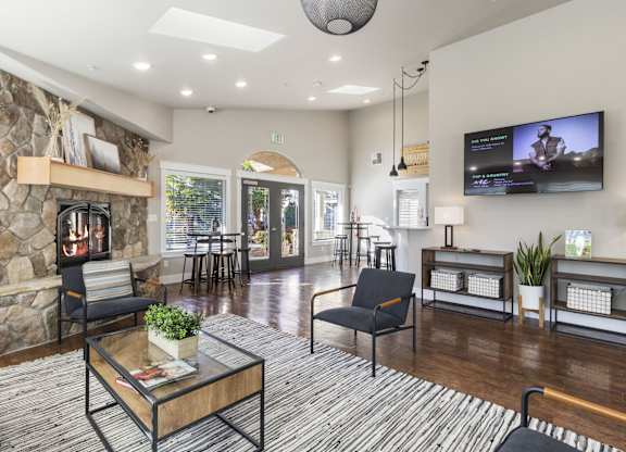 Community Club House Fireplace Lounge with dark flooring, tables and chairs and fireplace at Hearthstone Apartmentws