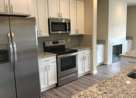 a kitchen with stainless steel appliances and white cabinets