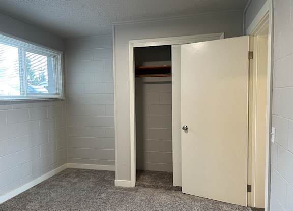 A white door is open to a small storage space.