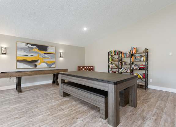 Community Clubhouse library and lounge space with seating, large table, book shelves, and yard games