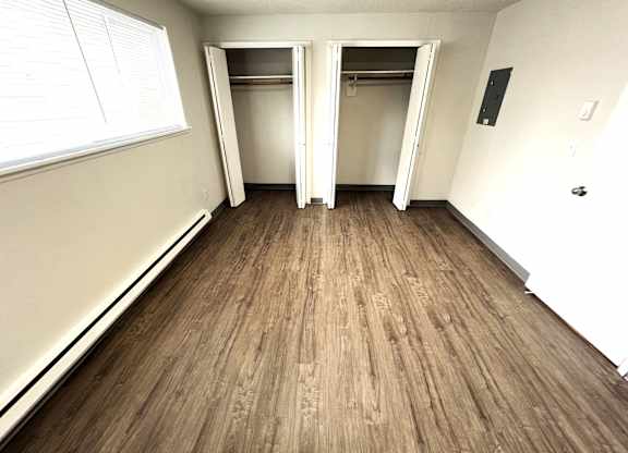 A room with wooden flooring and white walls.