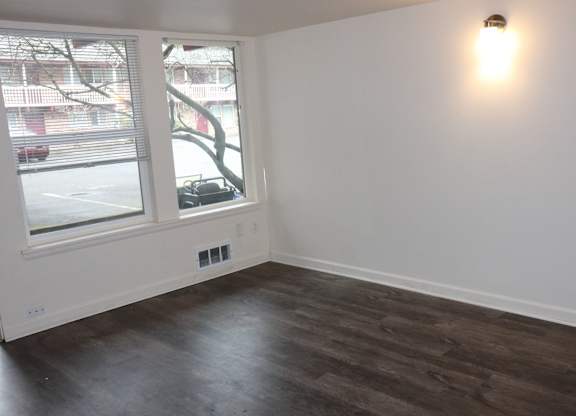 Living room for 2 bedroom apartment with large windows and vinyl plank dark wood flooring at Horizon Park Apartments