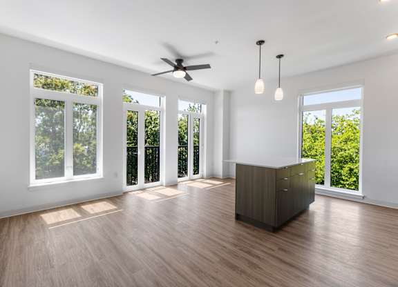 A spacious room with a ceiling fan and sliding glass doors at The Hub Apartments, Washington 98503
