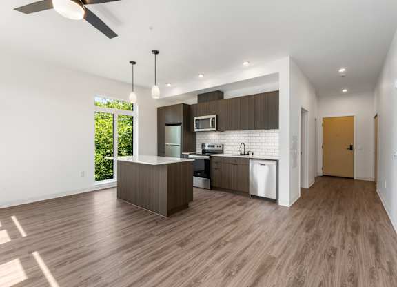 A modern kitchen with a wooden floor and white walls at The Hub Apartments, Washington