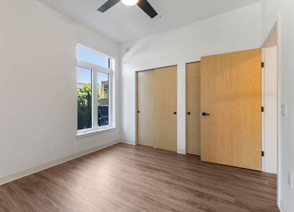 A room with a ceiling fan and three closed doors at The Hub Apartments, Lacey, 98503