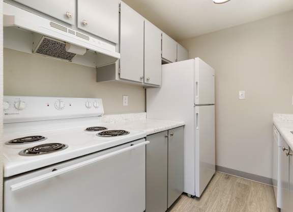A kitchen with white appliances and cabinets.